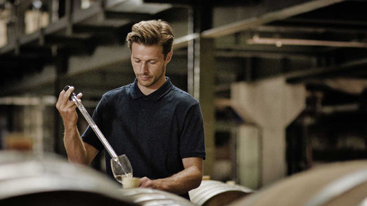 Ein Winzer überprüft den Alkoholgehalt von Wein im Weinkeller