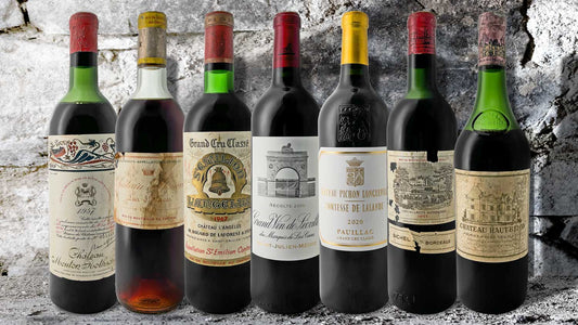 Die besten Weine aus Bordeaux stehen nebeneinander vor einer Steinwand