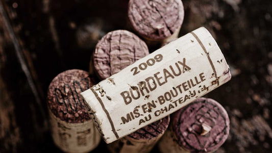 Mehrere Weinkorken aus Bordeaux liegen auf dem Tisch.