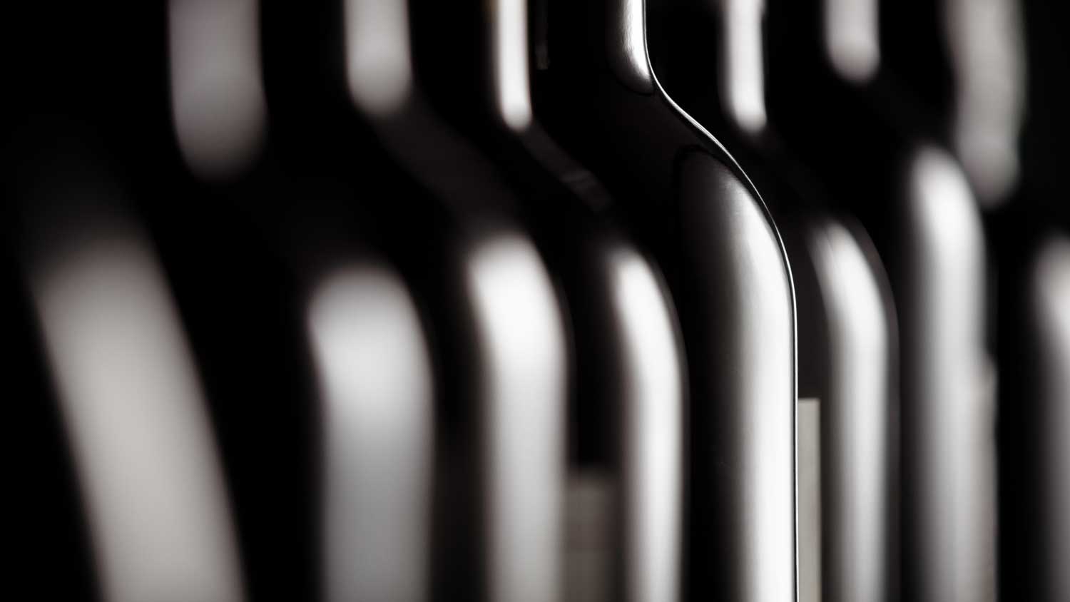 Eine Nahansicht von vielen Weinflaschen, die in einer Reihe stehen.