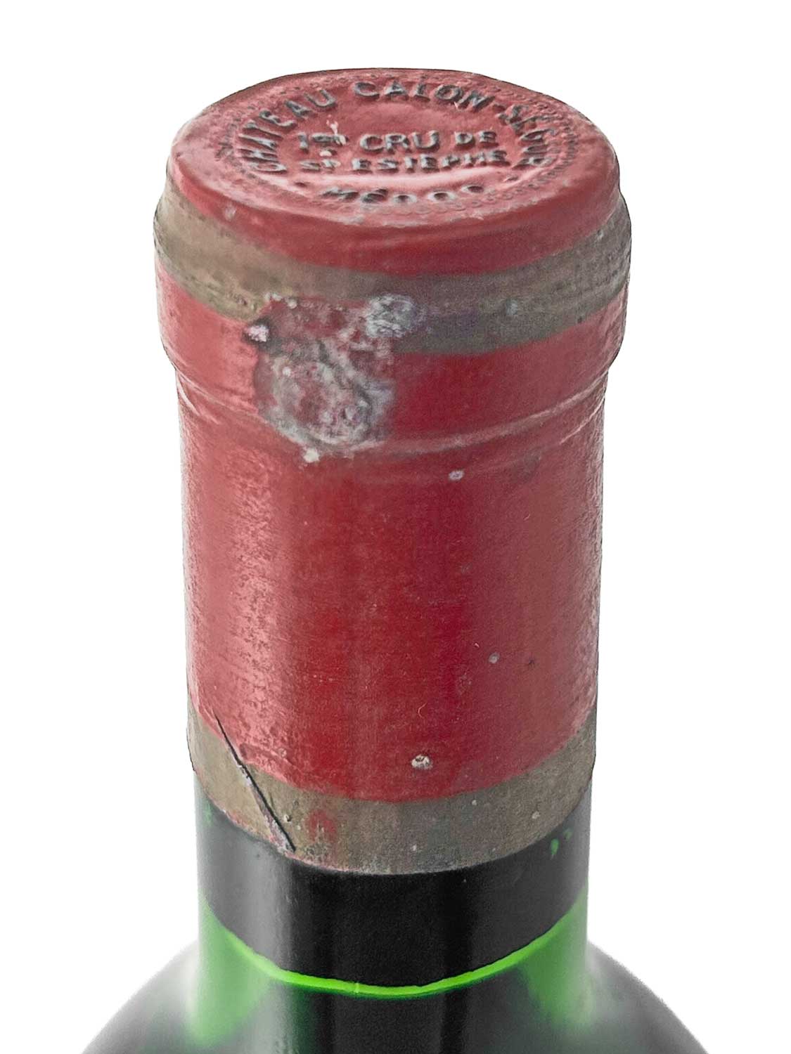 Nahaufnahme des Flaschenhalses einer Weinflasche mit rotem Siegel und Prägung 'CHATEAU CALON SEGUR 3e CRU DE BORDEAUX' auf dem Kapselkopf