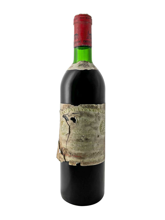 Flasche Chateau Cheval Blanc 1970 mit beschädigtem Etikett und rotem Kapselverschluss. Die Flasche ist aus grünem Glas.