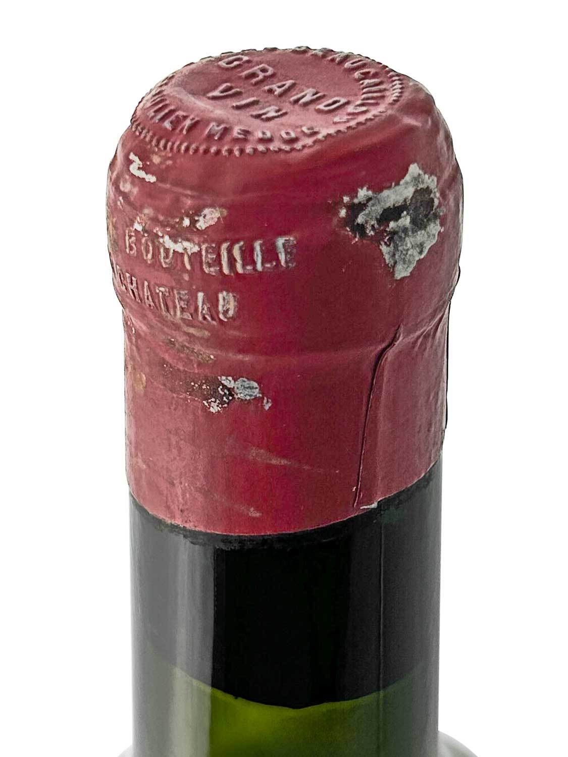 Nahaufnahme des Flaschenhalses einer Weinflasche mit roter Kapsel, die teilweise beschädigt ist.