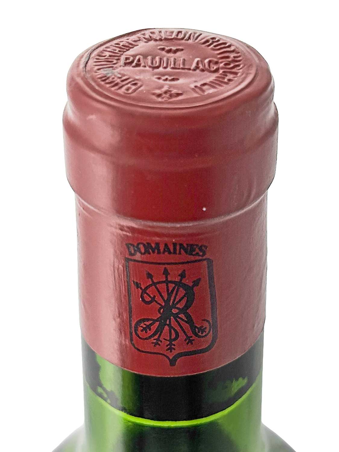Nahaufnahme des roten Flaschenhalses eines Château Duhart-Milon 1980 Weins mit geprägtem Schriftzug 'PAUILLAC' auf dem Kapselkopf und schwarzem Wappen mit verschlungenen Buchstaben auf dem Hals.
