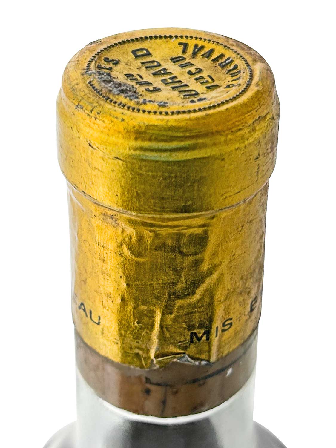 Gelbe Kapsel mit schwarzer Prägung und Text 'Château Guiraud Sauternes' auf dem Flaschenhals eines Dessertweins.