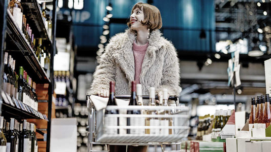 Frau mit Einkaufswagen in einem Weinladen