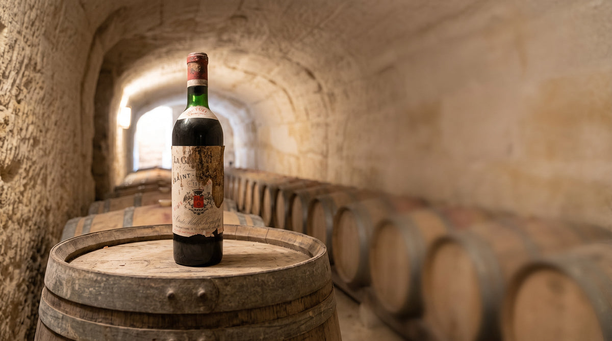 Gereifte Flasche Château La Gaffelière auf einem Eichenfass in einem alten Kalksteinkeller mit Fassreihen