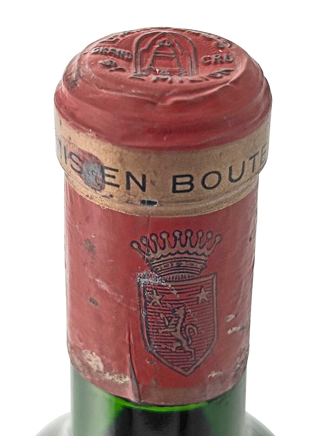 Rote Kapsel einer Weinflasche mit geprägtem Wappen und der Aufschrift 'MIS EN BOUTEILLE'. Oben ist das Logo von Chateau Angelus zu sehen.