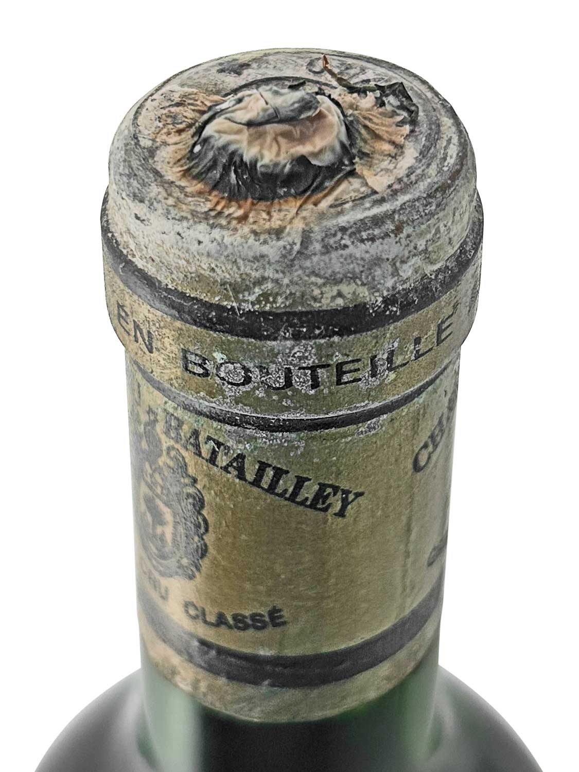 Draufsicht auf eine Weinflasche mit leicht beschädigter Kapsel. Darauf geschrieben steht 'Chateau Batailley 1985' und 'Cinquième Cru Classé'.