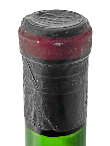 Flaschenkorken mit rotem und schwarzem Siegel, auf dem teilweise der Schriftzug 'SERVE AL' sichtbar ist.