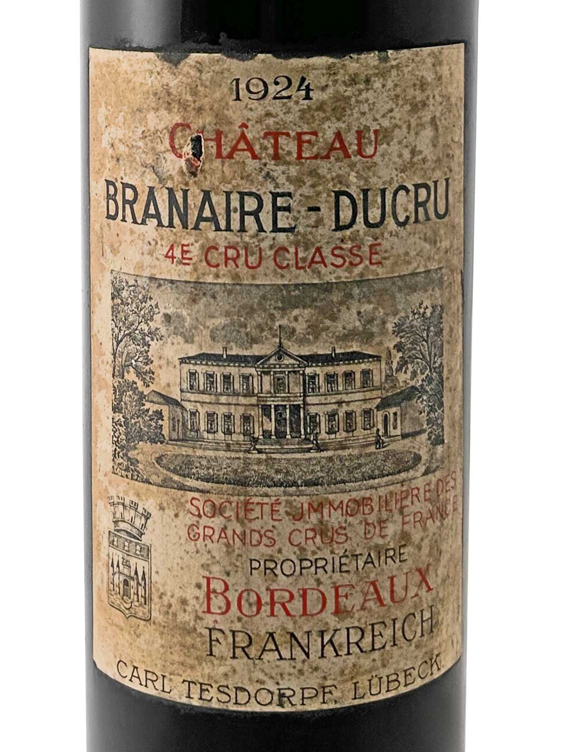Weinflasche mit Etikett von Château Branaire-Ducru, Jahrgang 1924. Abgebildet ist das Weingut, darunter steht 'Société Immobilière des Grands Crus de France', 'Propriétaire', 'Bordeaux', 'Frankreich' und 'Carl Tesdorpf Lübeck'.