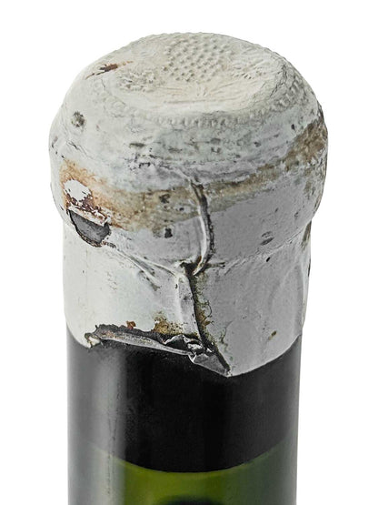 Kapsel einer Weinflasche von Chateau Branaire Ducru 1924, mit beschädigtem, grauem Verschluss und sichtbaren Abnutzungsspuren.