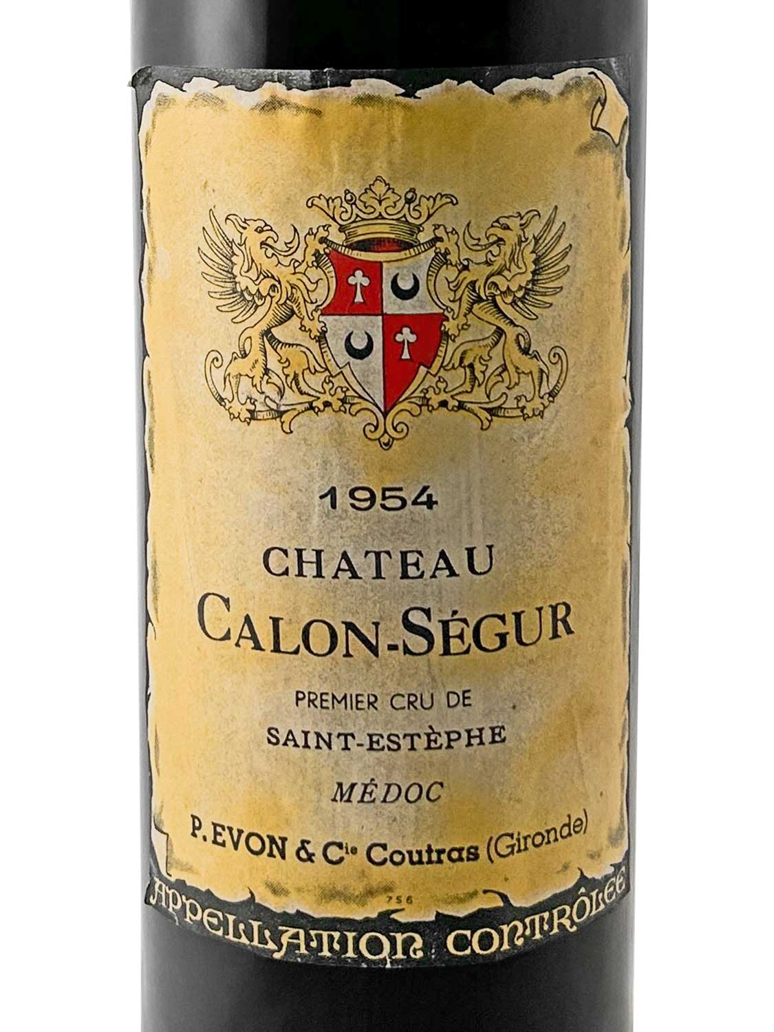 Weinflasche mit Etikett von Chateau Calon-Ségur 1954. Das Etikett zeigt ein Wappen mit zwei Löwen. Text: 'CHATEAU CALON-SÉGUR', '1954', 'PREMIER CRU DE SAINT-ESTÈPHE', 'MÉDOC', 'P. EVON & Cie'.