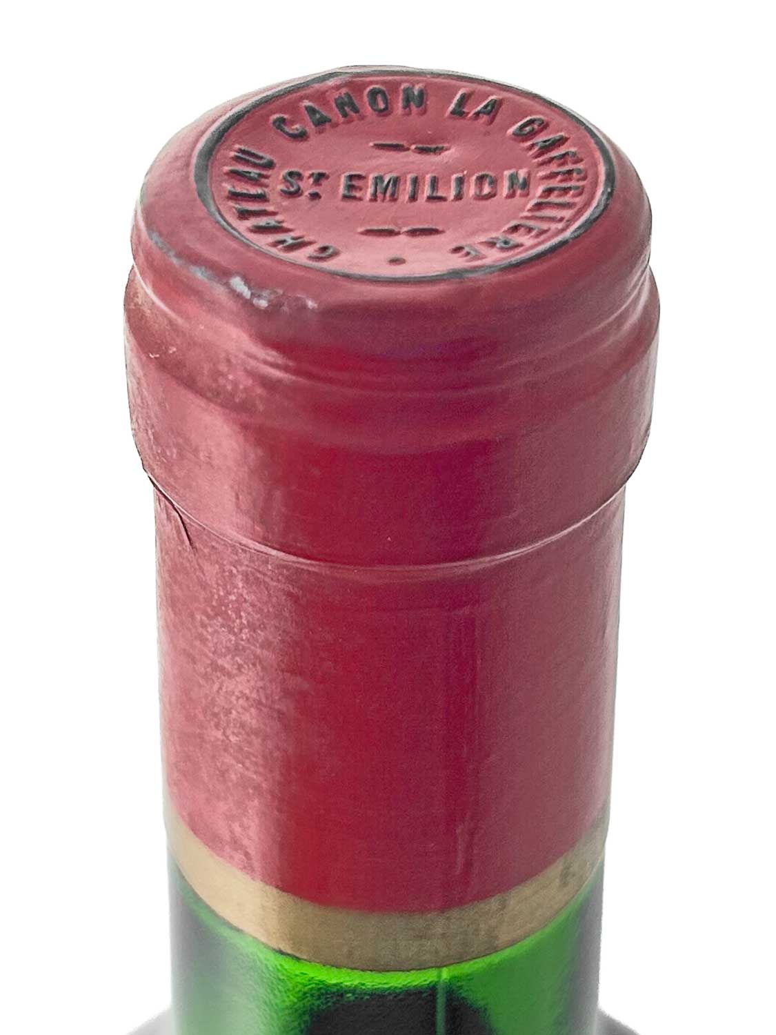 Flaschenhals mit rotem Kapselverschluss, auf dem 'CHATEAU CANON LA GAFFELIERE ST EMILION' geprägt ist