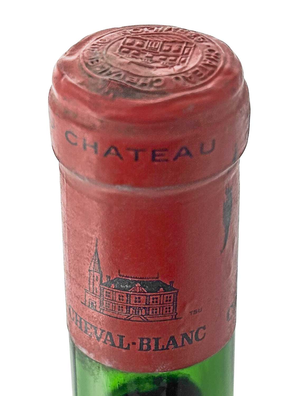 Rote Kapsel einer Weinflasche mit dem eingeprägten Text 'CHATEAU'. Auf dem Kapselverschluss ist ein Wappen und eine Abbildung des Chateau Cheval Blanc zu sehen.