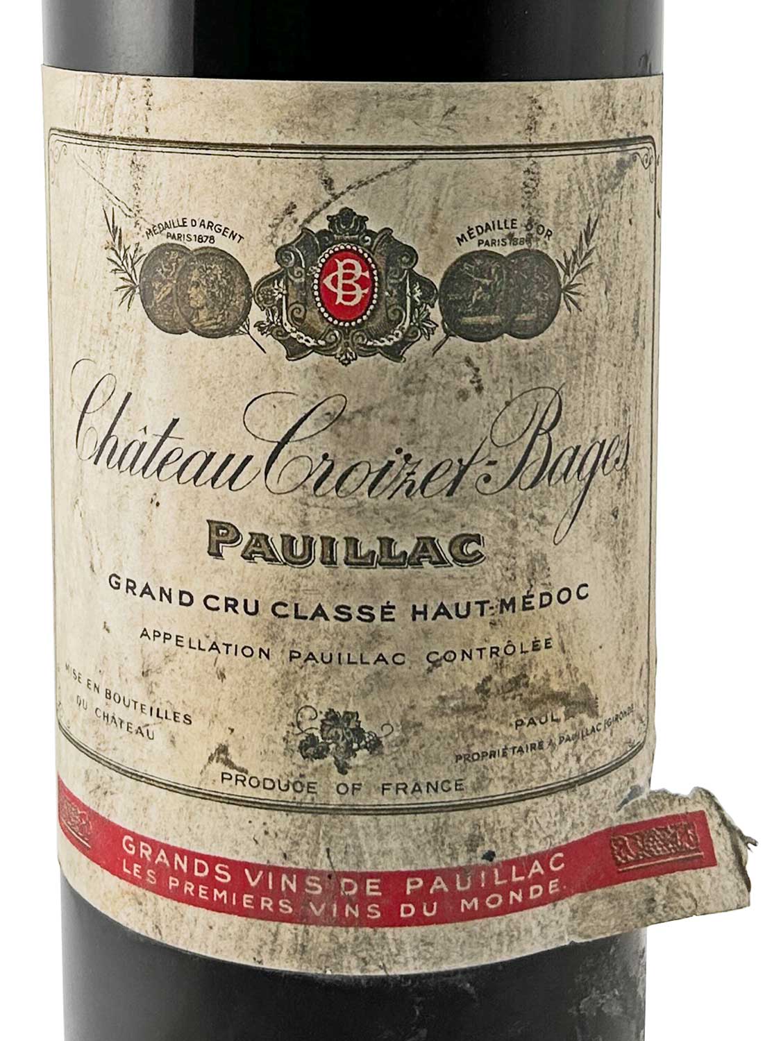 Weinflasche mit altem, leicht beschädigtem Etikett von Château Croizet-Bages 1962, Pauillac, Grand Cru Classé Haut-Médoc, mit Medaillenabbildungen und rotem Schriftband am Flaschenhals.