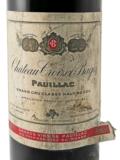 Weinflasche mit altem, leicht beschädigtem Etikett von Château Croizet-Bages 1962, Pauillac, Grand Cru Classé Haut-Médoc, mit Medaillenabbildungen und rotem Schriftband am Flaschenhals.