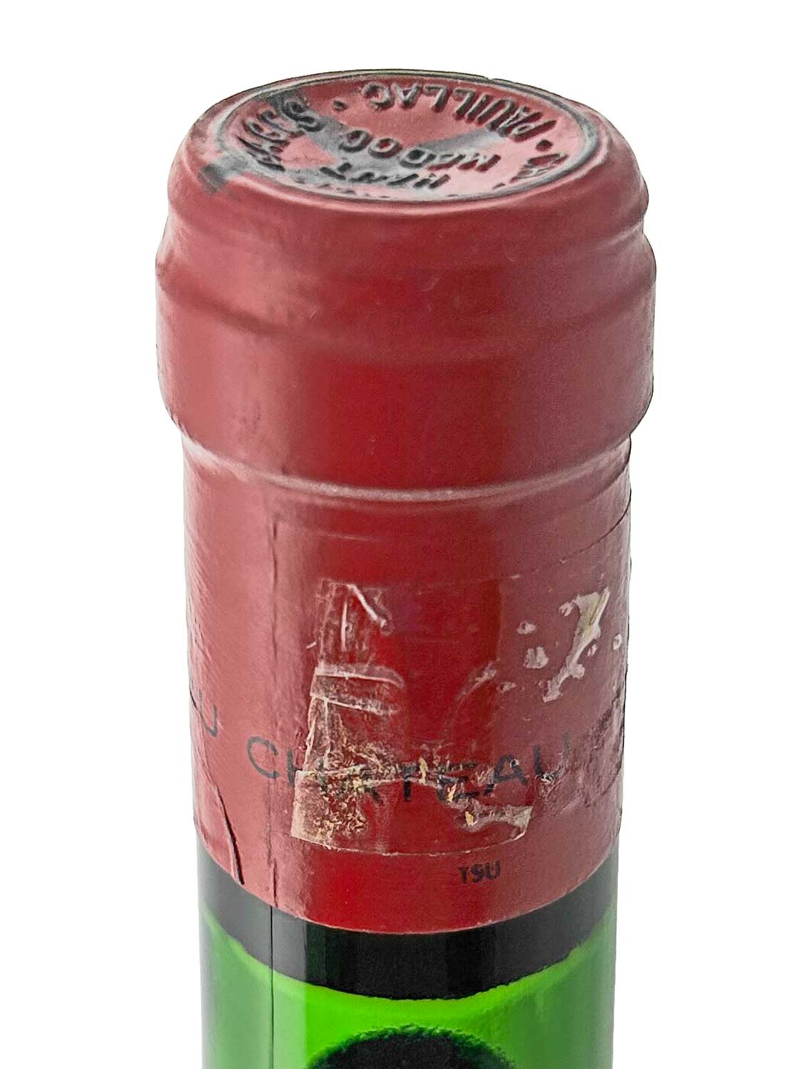 Grüner Weinflaschenhals mit rotem Kapselverschluss, teilweise beschädigtem Etikett und Prägung auf der Oberseite.