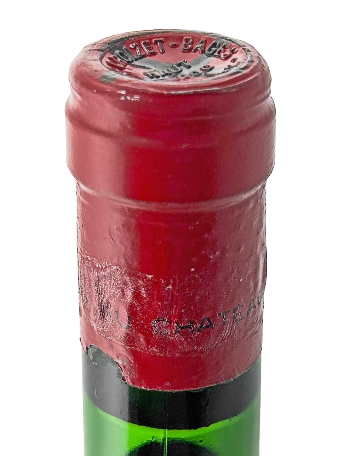 Nahaufnahme des roten Flaschenhalses und Kapsel einer Weinflasche mit geprägtem Schriftzug 'CROIZET-BAGES' auf der Kapsel