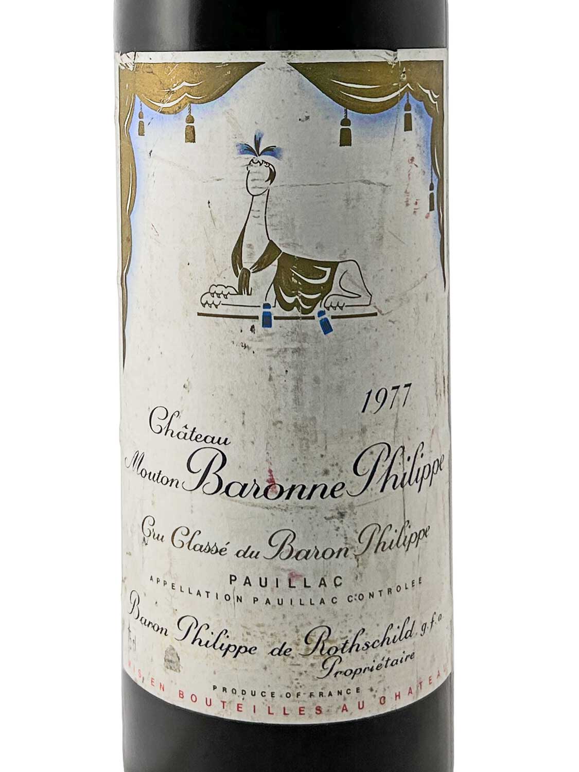 Weinflasche Château Mouton Baronne Philippe 1977 mit Etikett, das eine stilisierte Figur eines liegenden Tieres zeigt.