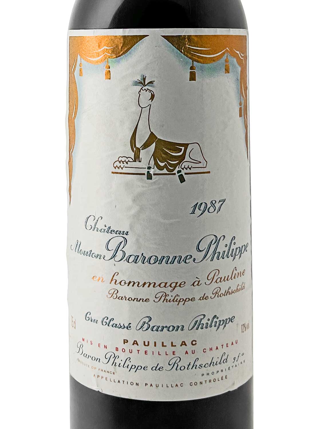 Weinflasche Château d'Armailhac 1987 mit Etikett, das eine stilisierte Sphinx und Text in Schwarz und Orange zeigt.