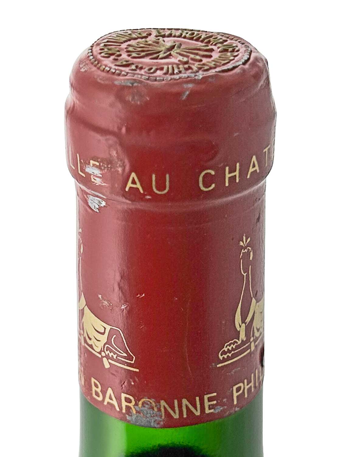 Flaschenkapsel eines Château d'Armailhac 1987 mit rotem Siegel und goldener Schrift sowie goldfarbenen Tiermotiven.