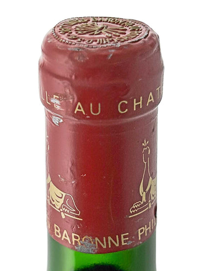 Flaschenkapsel eines Château d'Armailhac 1987 mit rotem Siegel und goldener Schrift sowie goldfarbenen Tiermotiven.