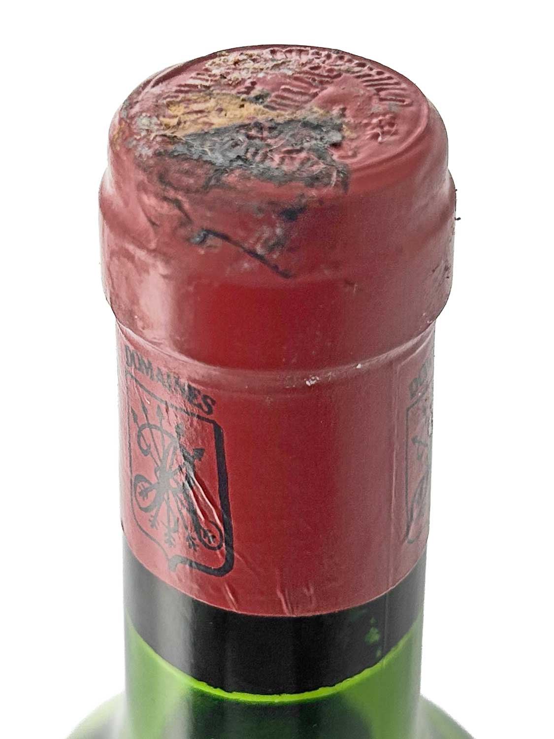 Flasche mit rotem Kapselverschluss und geprägtem Siegel am Flaschenhals, teilweise beschädigt