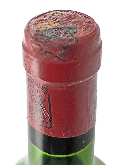 Flasche mit rotem Kapselverschluss und geprägtem Siegel am Flaschenhals, teilweise beschädigt