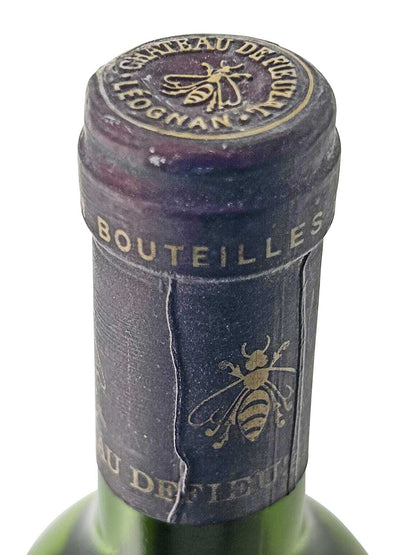 Verschlusskapsel einer Weinflasche mit goldener Bienenabbildung und Schrift 'CHATEAU DE FIEUZAL PESSAC-LEOGNAN' und 'BOUTEILLES'.