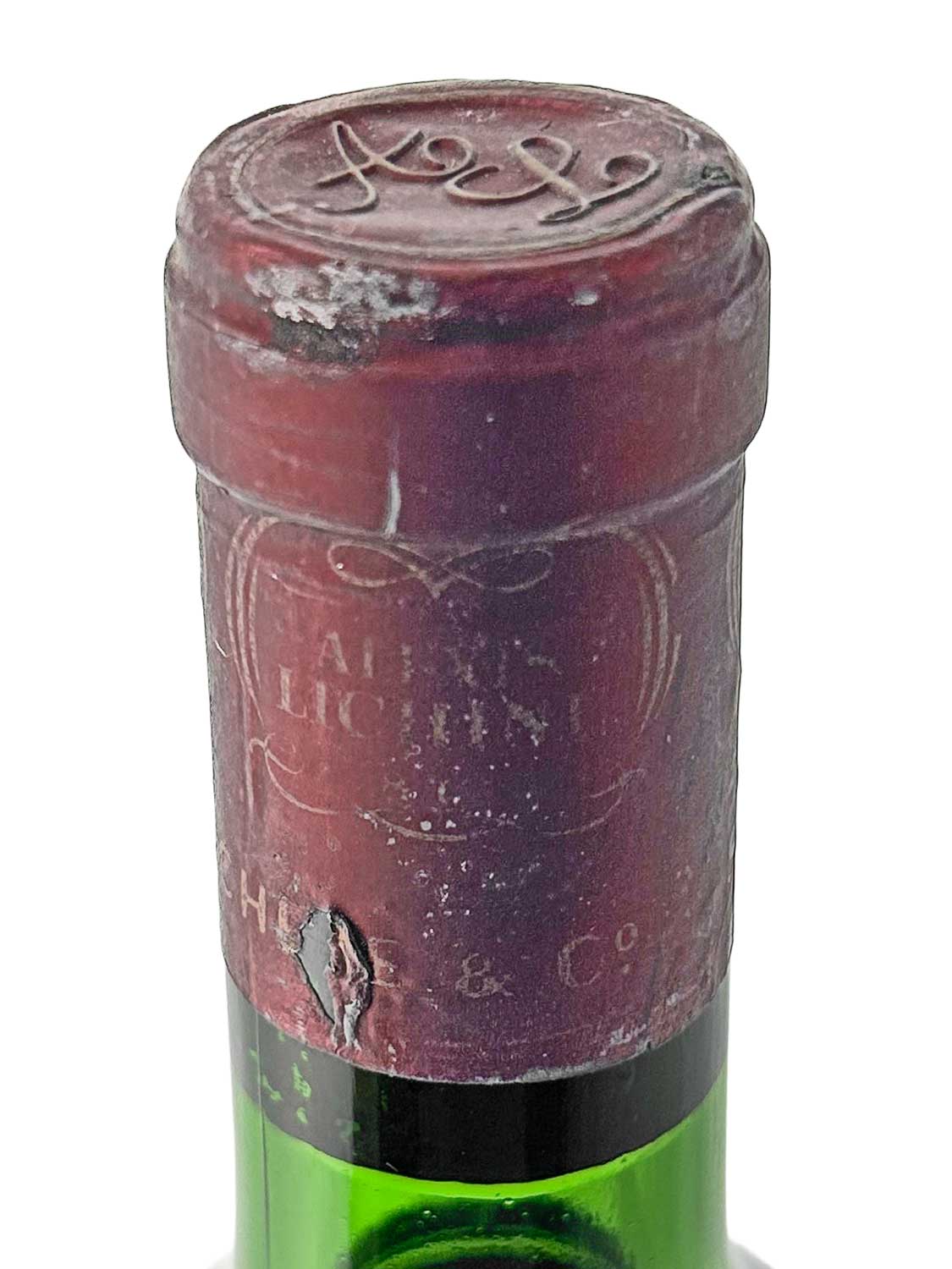 Nahaufnahme des Flaschenhalses einer grünen Weinflasche mit rotem Kapselverschluss, auf dem die Jahreszahl '1969' geprägt ist