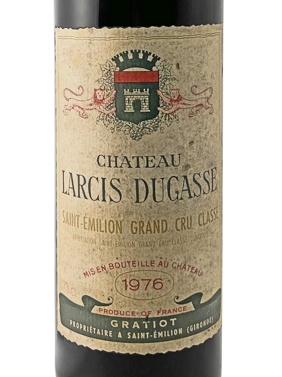 Weinflasche mit altem, vergilbtem Etikett von Château Larcis Ducasse 1976, Saint-Émilion Grand Cru Classé, mit Wappen und Text in Schwarz, Rot und Grün.