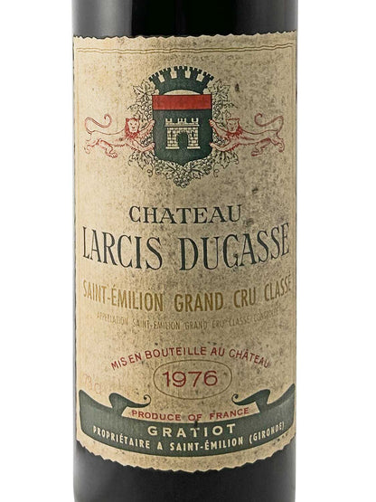Weinflasche mit altem, vergilbtem Etikett von Château Larcis Ducasse 1976, Saint-Émilion Grand Cru Classé, mit Wappen und Text in Schwarz, Rot und Grün.