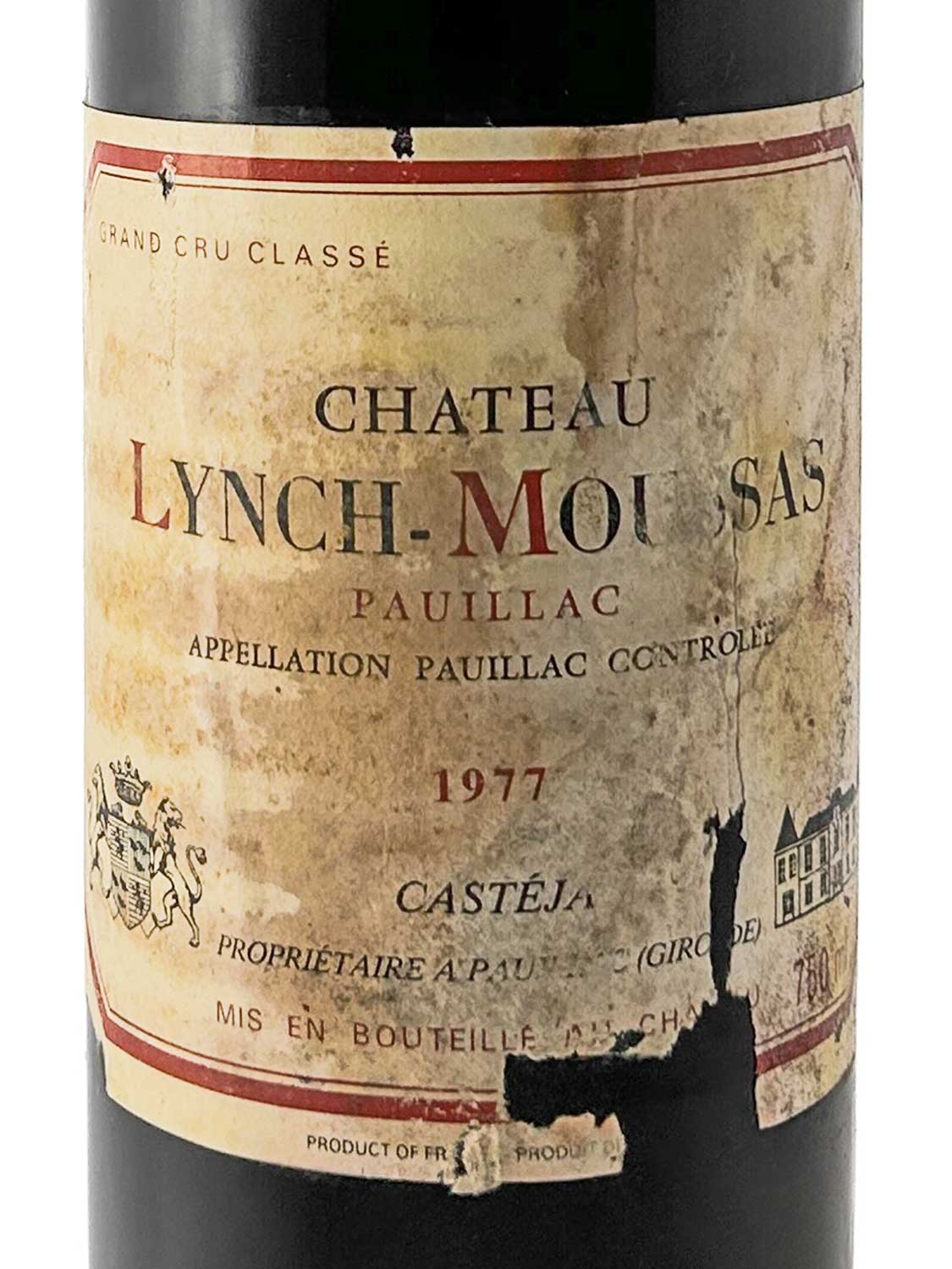Weinflasche mit altem, teilweise beschädigtem Etikett der Marke Château Lynch-Moussas aus dem Jahr 1977, mit Text und Wappen.