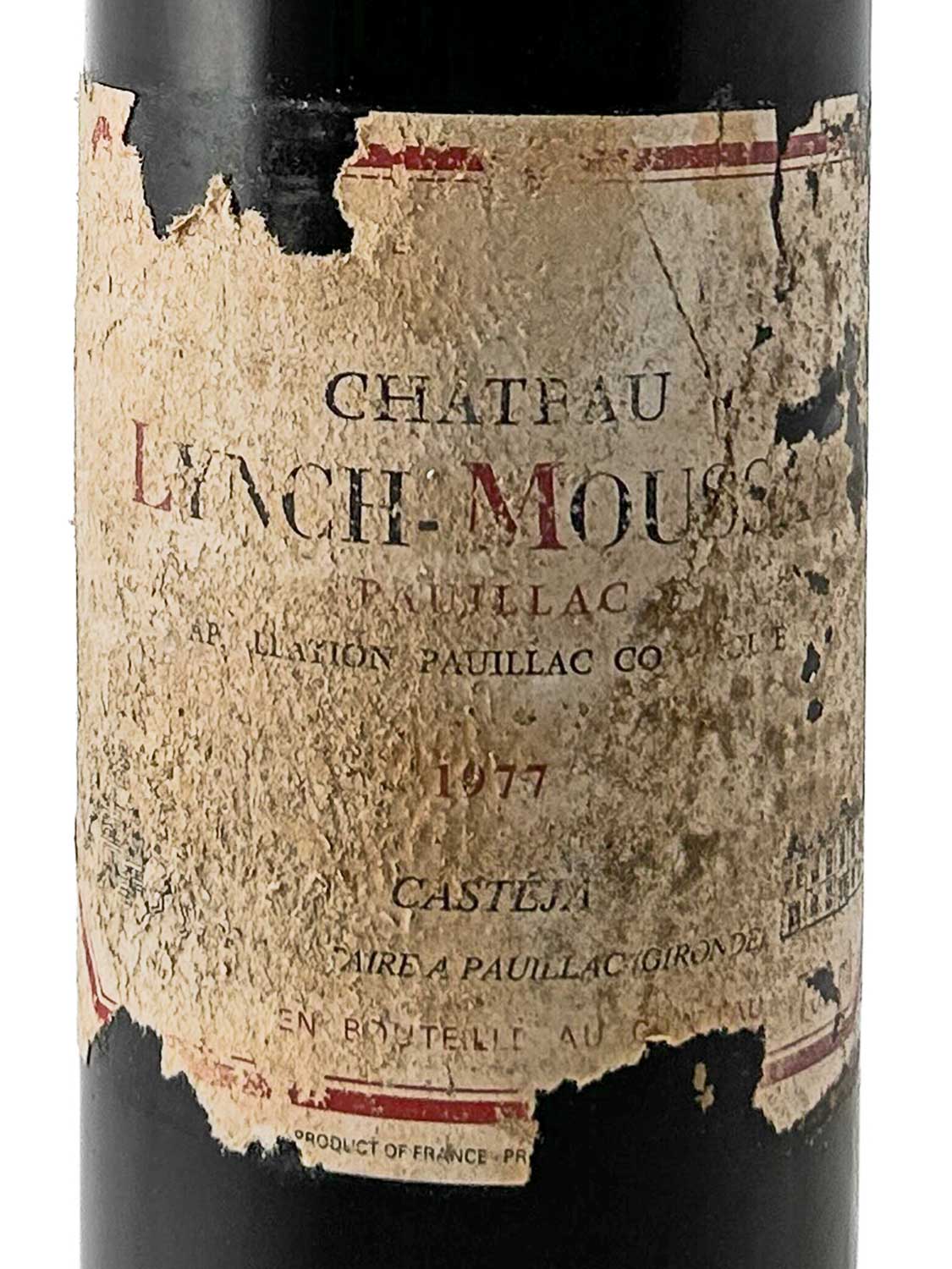 Weinflasche mit stark beschädigtem, vergilbtem Etikett der Marke Château Lynch-Moussas aus dem Jahr 1977