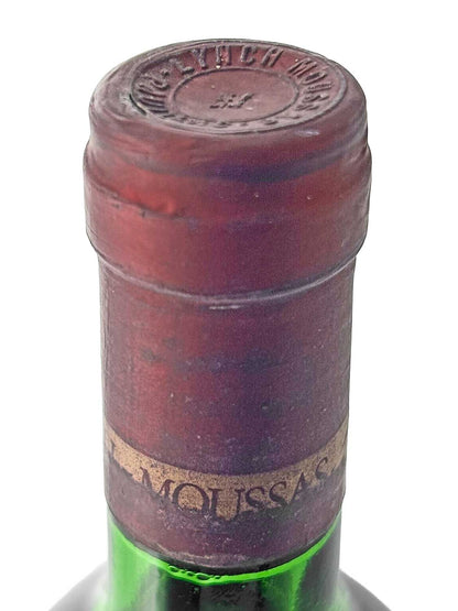 Flaschenhals einer grünen Weinflasche mit rotem Kapselverschluss und teilweise sichtbarem Etikett mit der Aufschrift 'MOUSSAS'