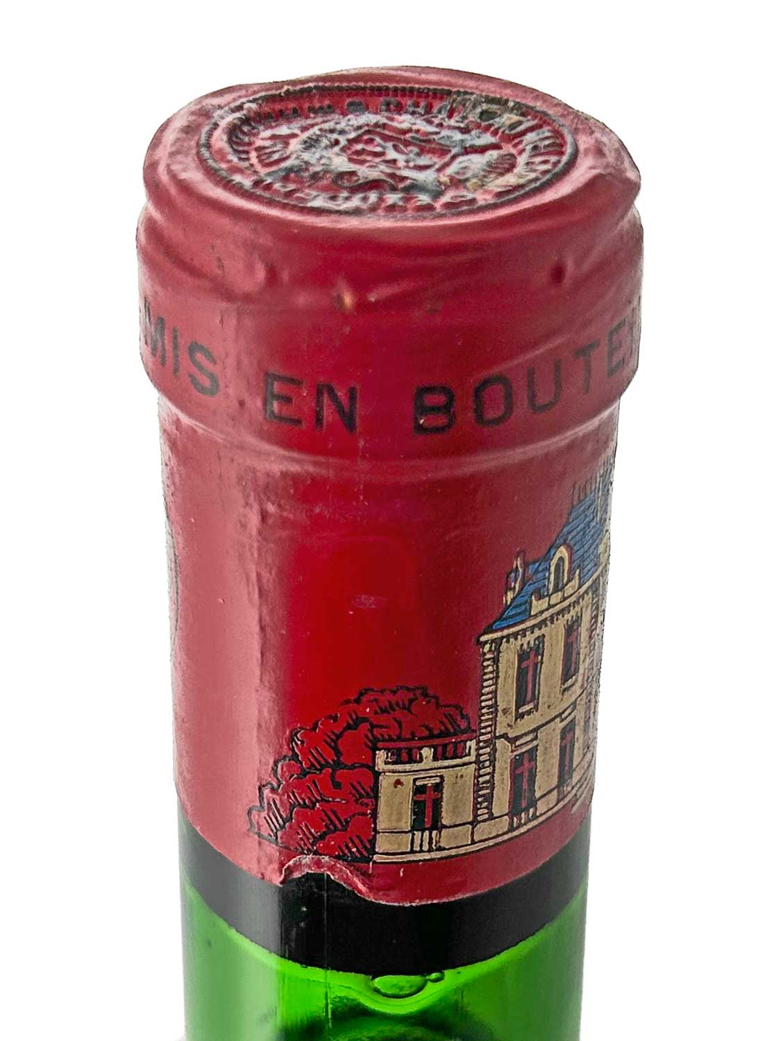 Nahaufnahme des Flaschenhalses einer grünen Weinflasche mit rotem Kapselverschluss und einem Etikett mit einem Schlossgebäude und roten Bäumen