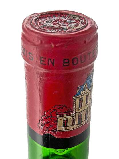 Nahaufnahme des Flaschenhalses einer grünen Weinflasche mit rotem Kapselverschluss und einem Etikett mit einem Schlossgebäude und roten Bäumen