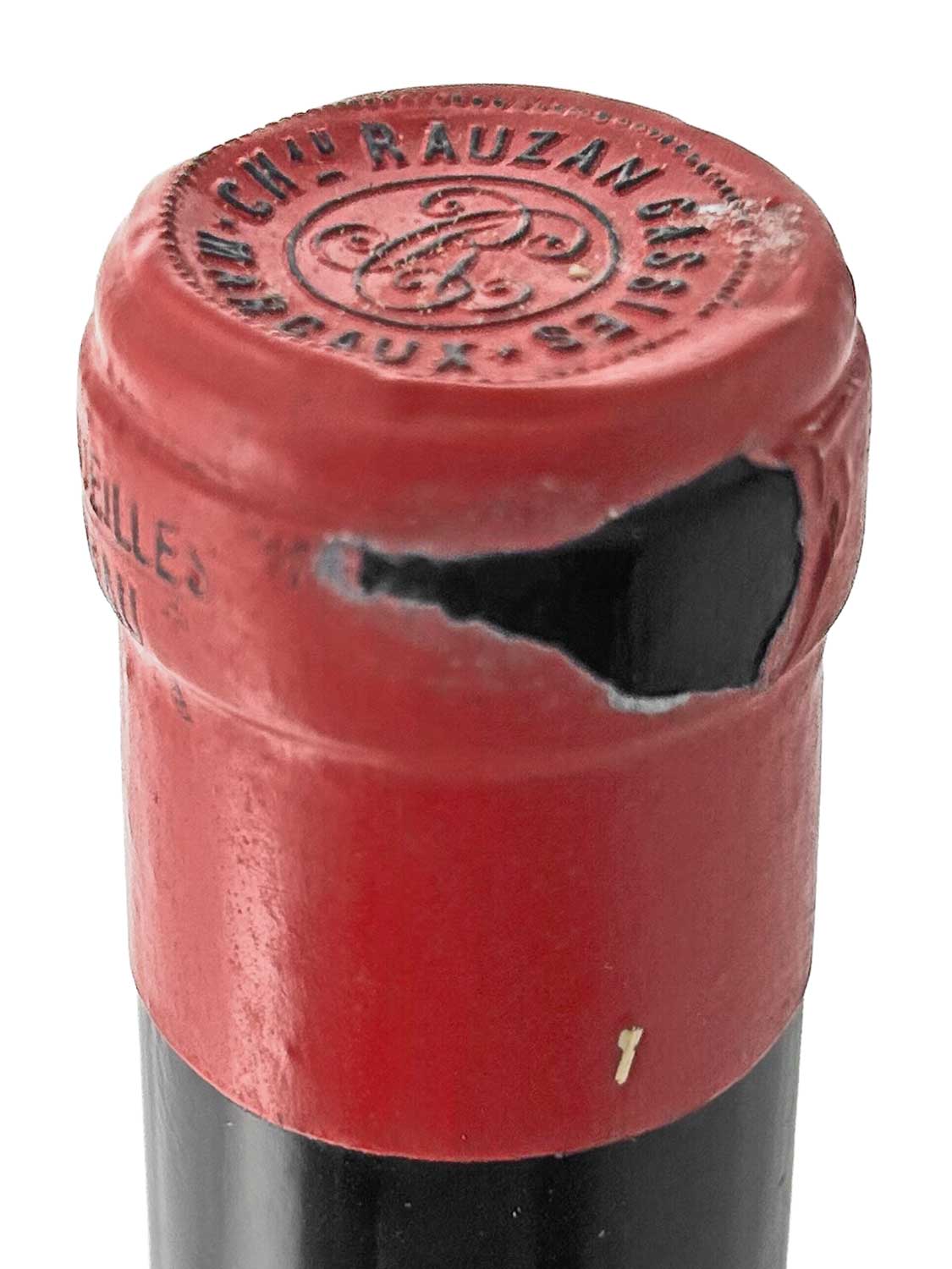 Nahaufnahme des Flaschenhalses einer Weinflasche mit rotem Kapselverschluss und der Prägung 'CHÂTEAU RAUZAN-GASSIES' auf dem oberen Teil der Kapsel