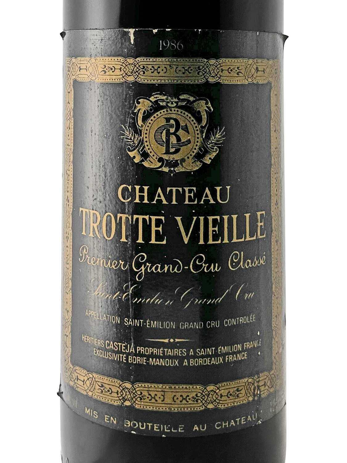 Weinflasche mit schwarzem Etikett, goldener Verzierung und der Aufschrift 'CHATEAU TROTTE VIEILLE Premier Grand-Cru Classé 1986'.