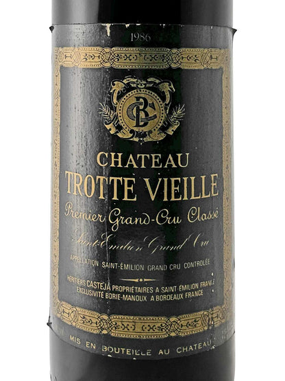 Weinflasche mit schwarzem Etikett, goldener Verzierung und der Aufschrift 'CHATEAU TROTTE VIEILLE Premier Grand-Cru Classé 1986'.
